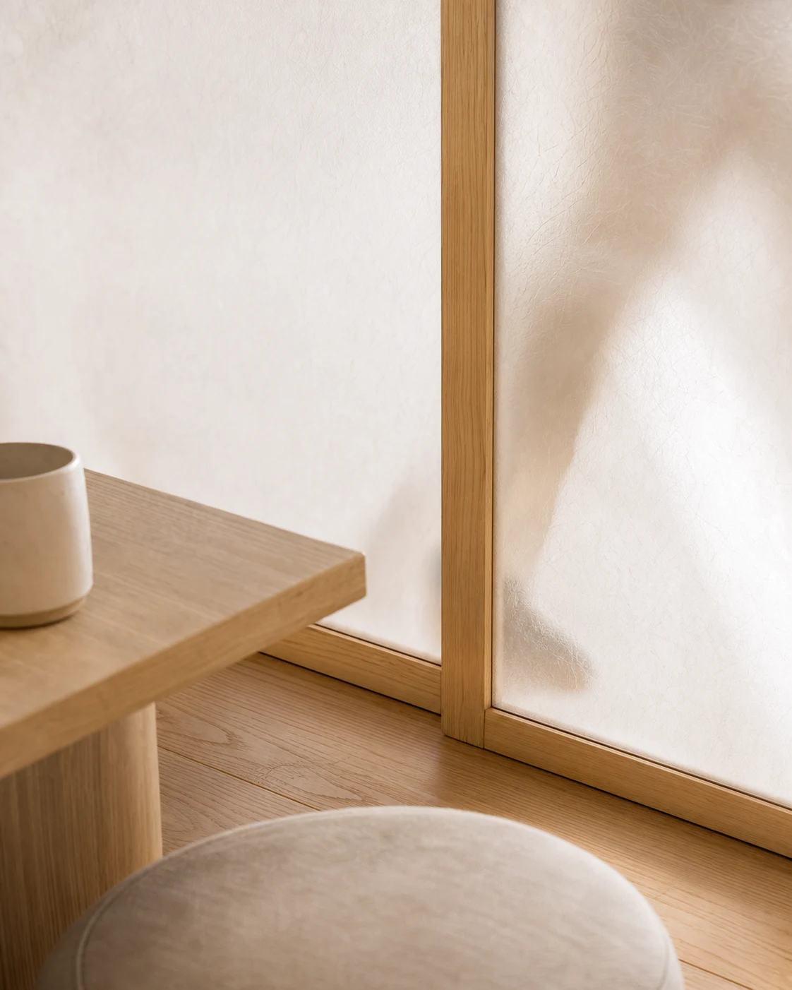 A sōmme concept study: soft daylight through a textured screen, pale wood, and a ceramic cup.